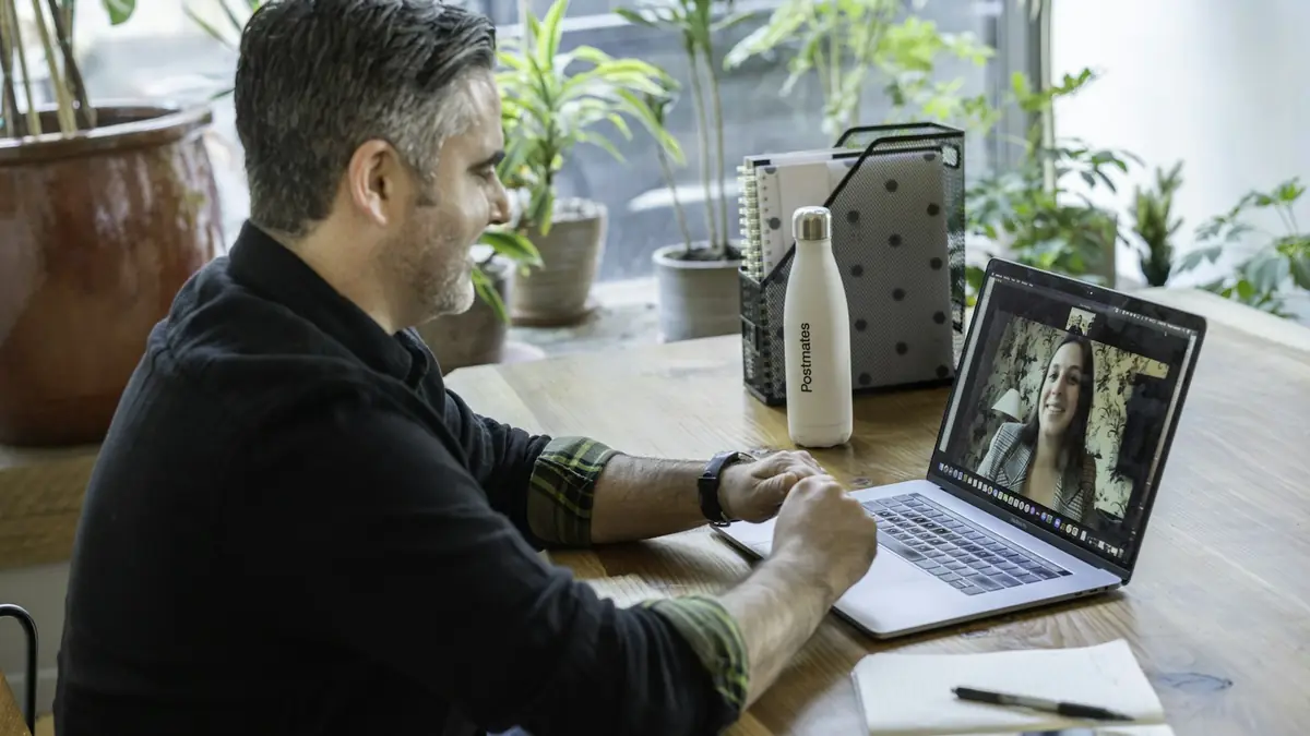 Developer working on a laptop at a wooden table