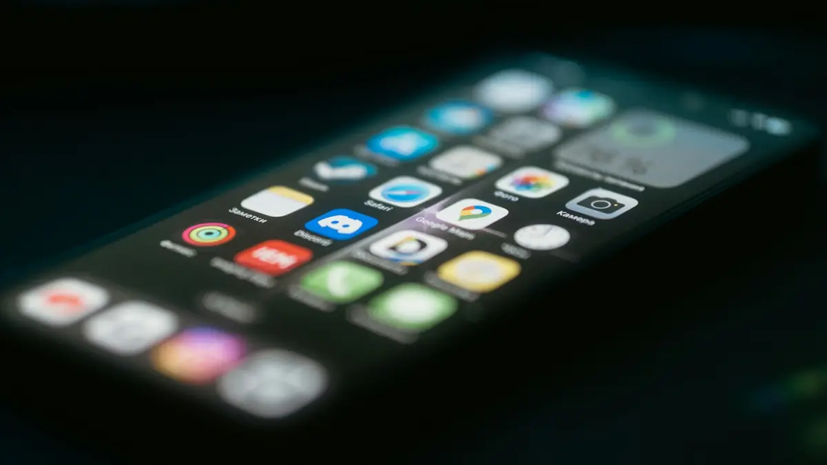 Smartphone showing app icons lying on a desk