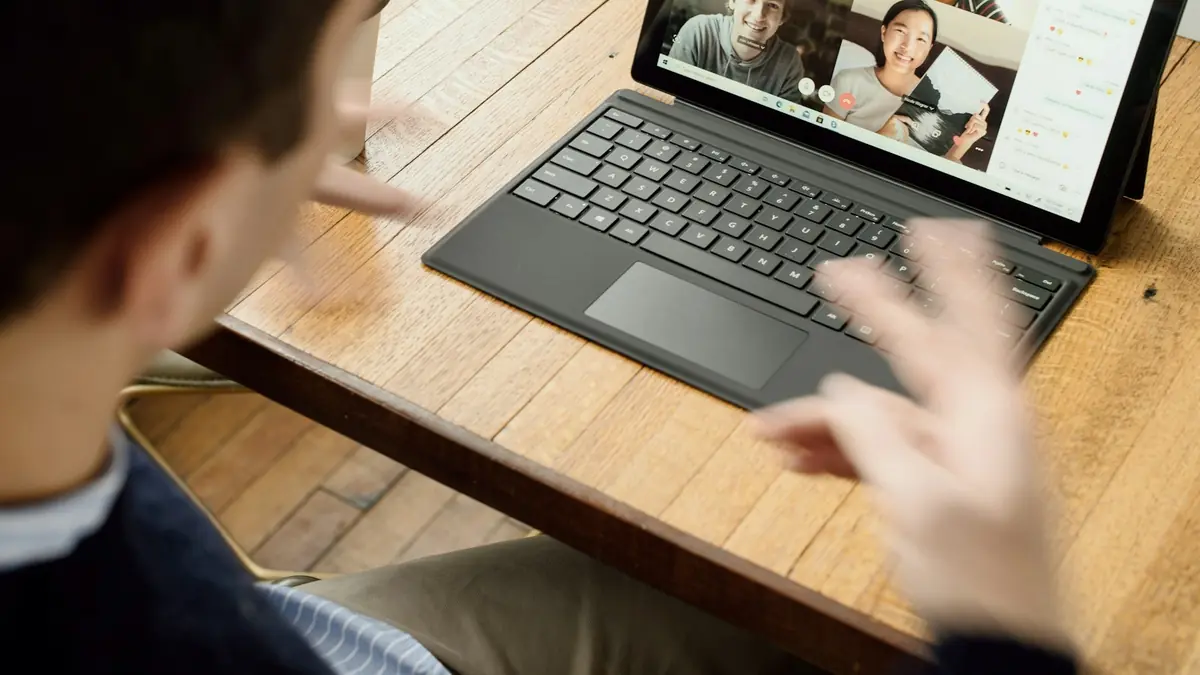Developer typing on a laptop during a video call